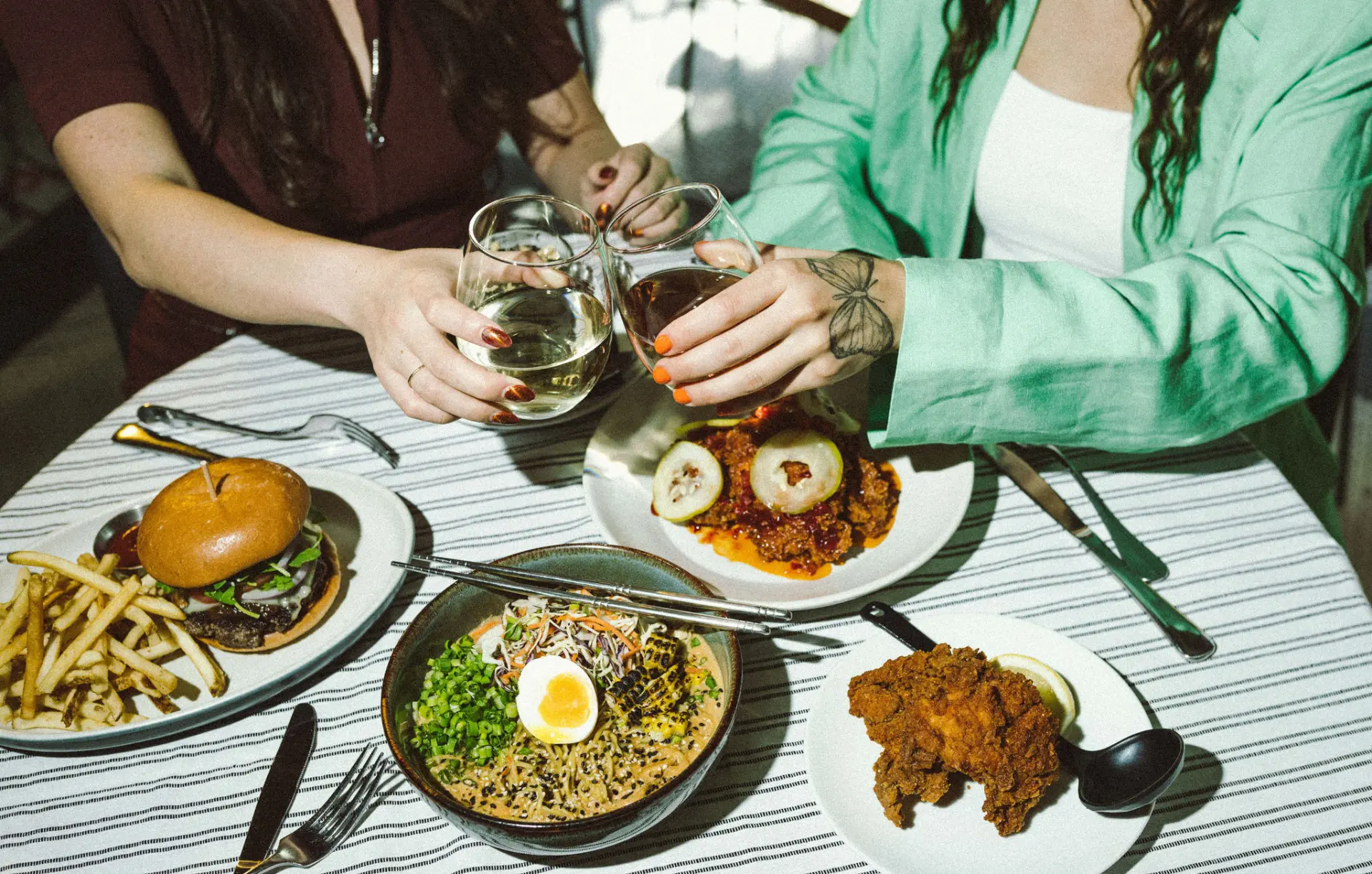 Friends toasting over shared plates at LOCAL Public Eatery in Sherwood Park