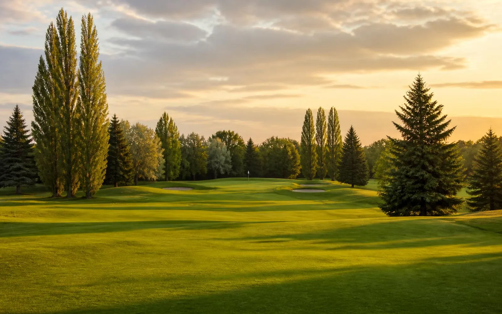 General golf-course atmosphere: a fairway and distant green at golden hour